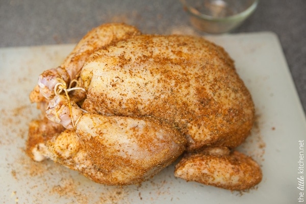 whole chicken tied with kitchen twine on a cutting board